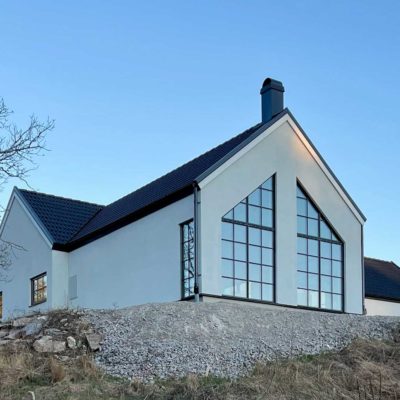 Vitt enplanshus med stora fönster